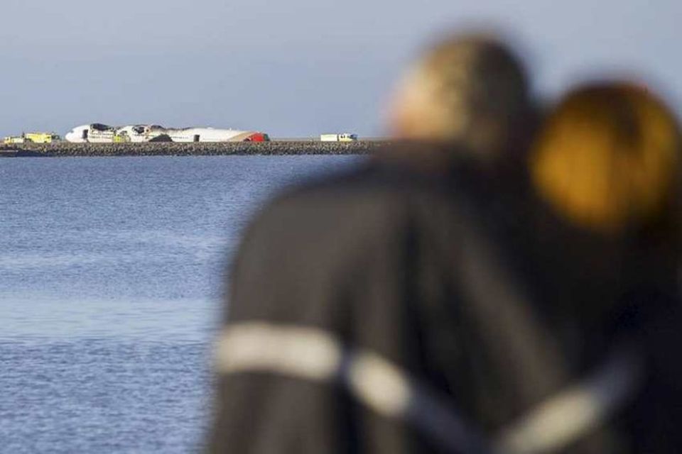 Vegfarendur virða flak vélarinnar fyrir sér.