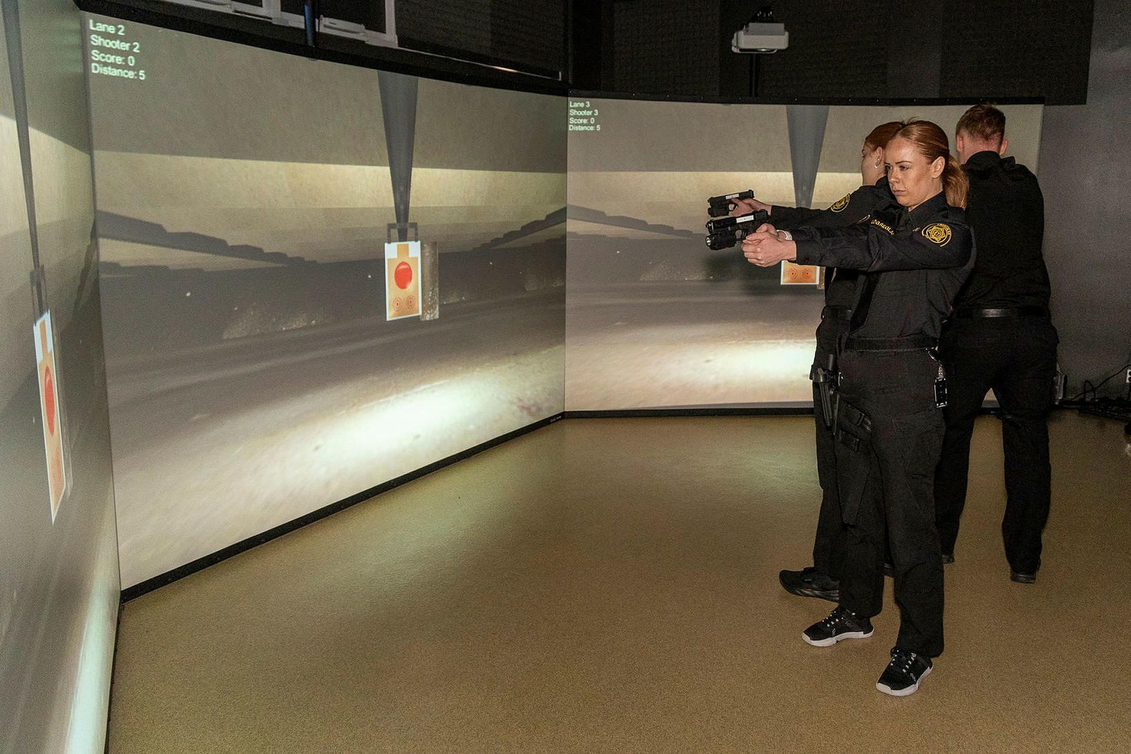 Lögreglunemar munda lasertengdar Glock-skammbyssur í hermi menntasetursins.