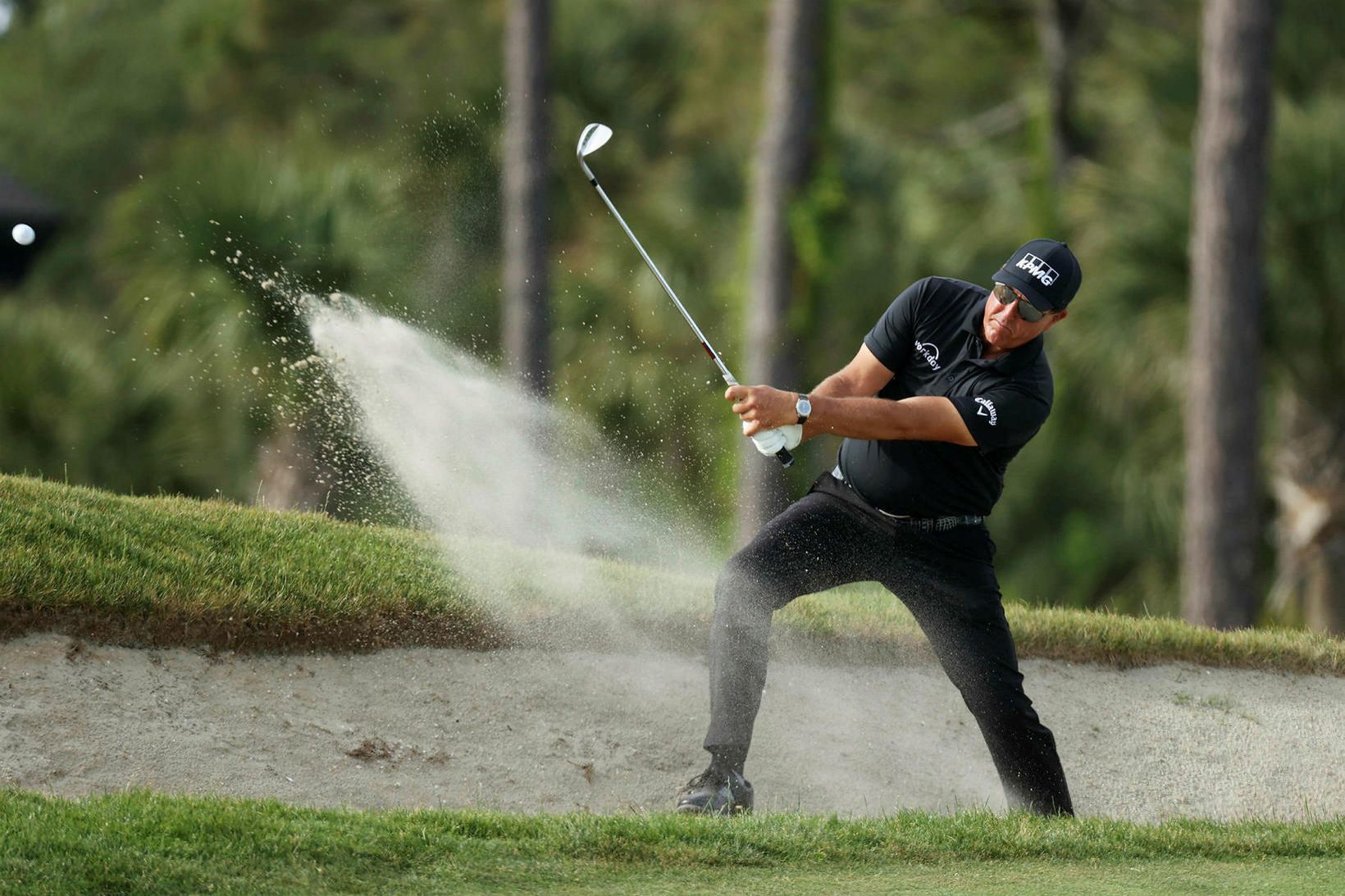 Phil Mickelson slær upp úr glompu á hringnum í gærkvöld.