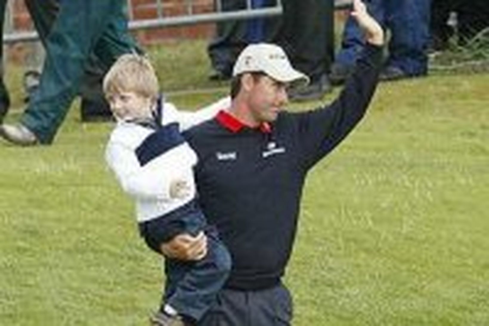 Padraig Harrington fagnar sigrinum með syni sínum, Patrick, á Carnoustie …