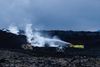 Firemen attempt to cool the lava with water
