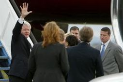 Bill Clinton veifar til viðstaddra áður en hann gengur um borð í flugvél sína á …