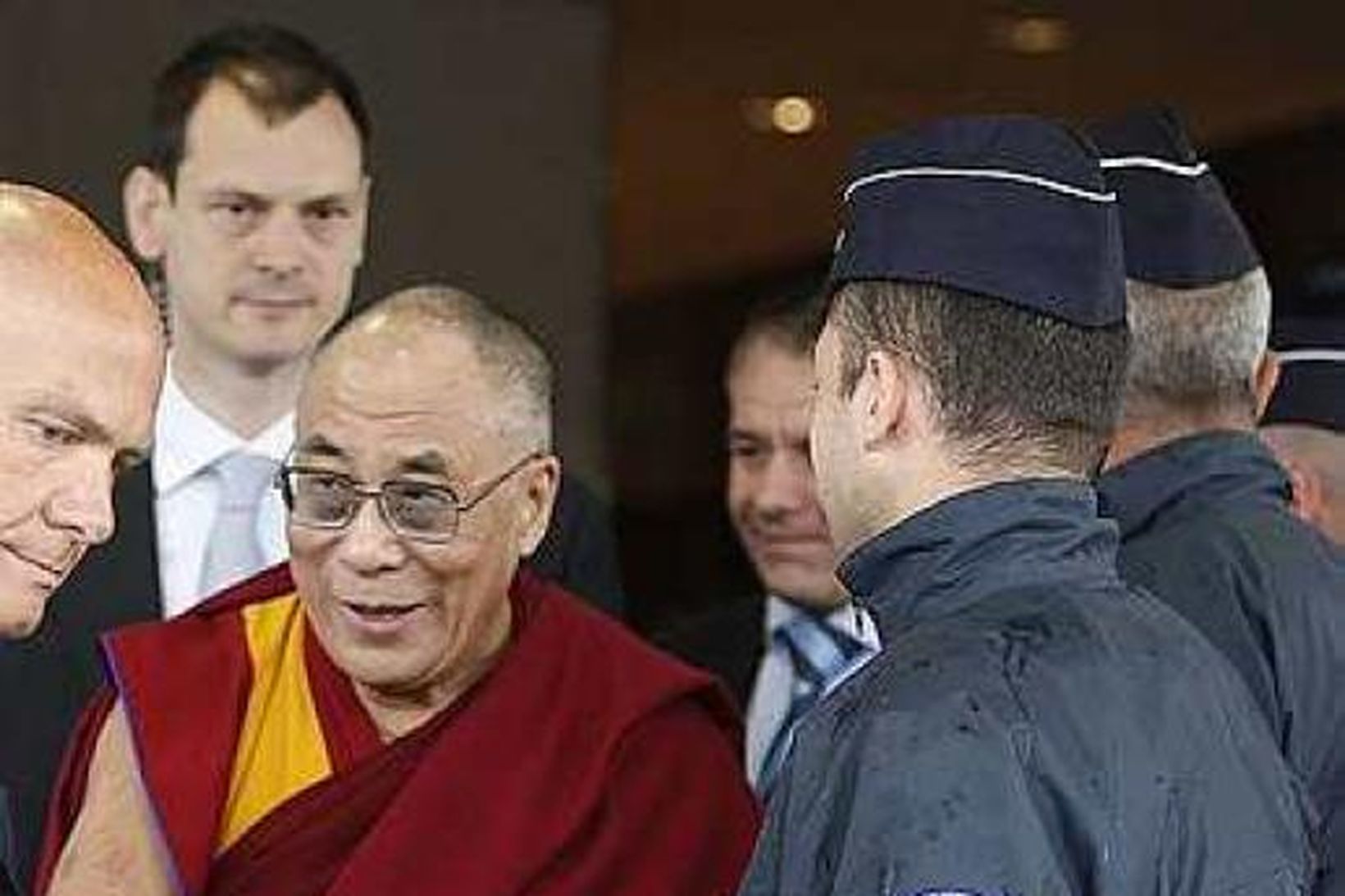 Dalai Lama heilsar lögreglumanni á Charles de Gaulle flugvellinum í …