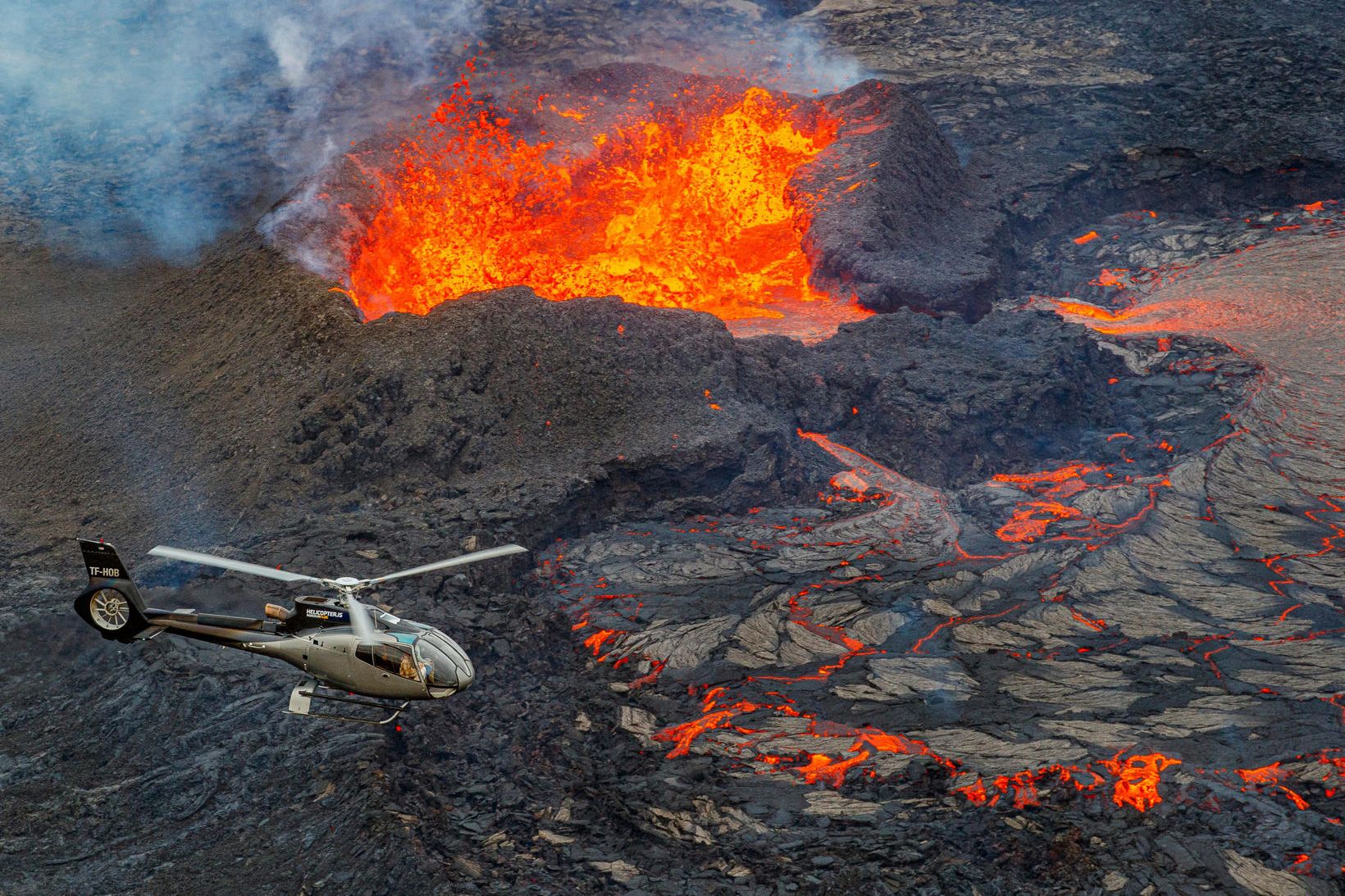 Þyrla Norðurflugs í útsýnisflugi yfir eldgosið við Litla-Hrút. Flugumferð yfir …