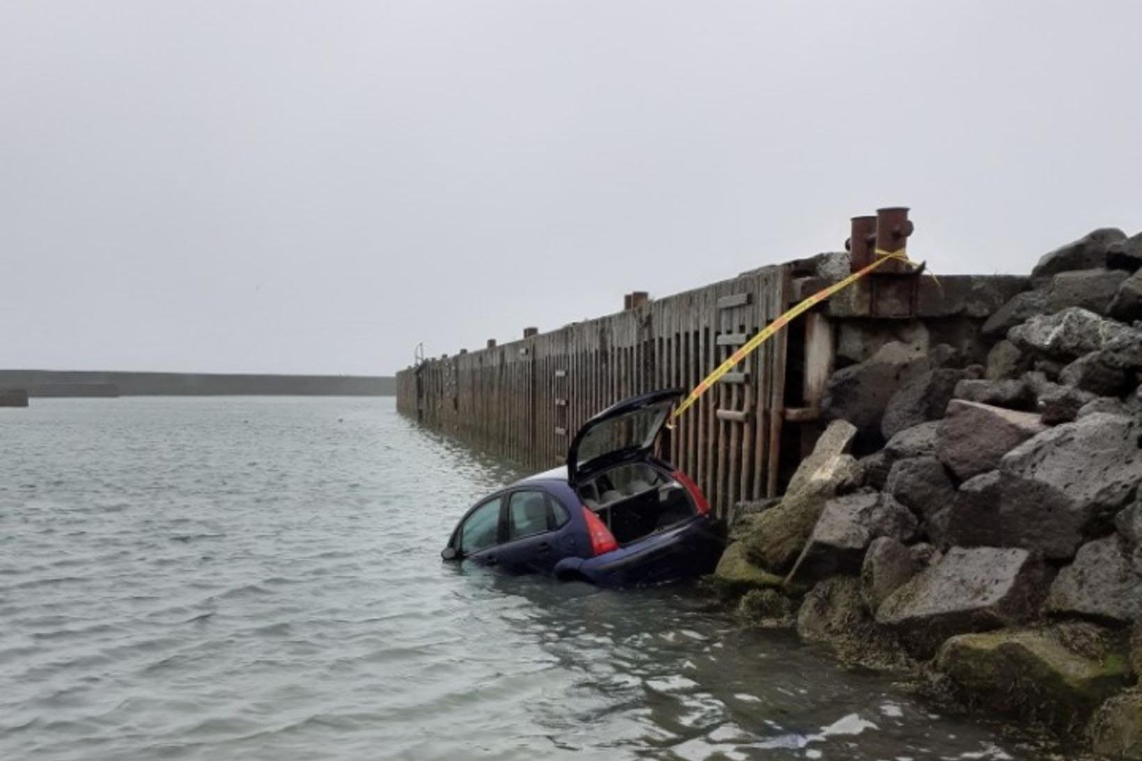 Verið er að draga bifreiðina upp úr sjónum á Eyrarbakka.