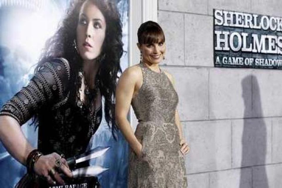 Noomi Rapace við auglýsingaspjald fyrir Sherlock Holmes: A Game of Shadows.