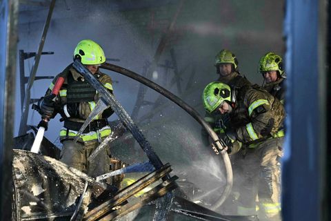 Úkraínskir slökkviliðsmenn að störfum í Kænugarði í morgun eftir árásir Rússa.