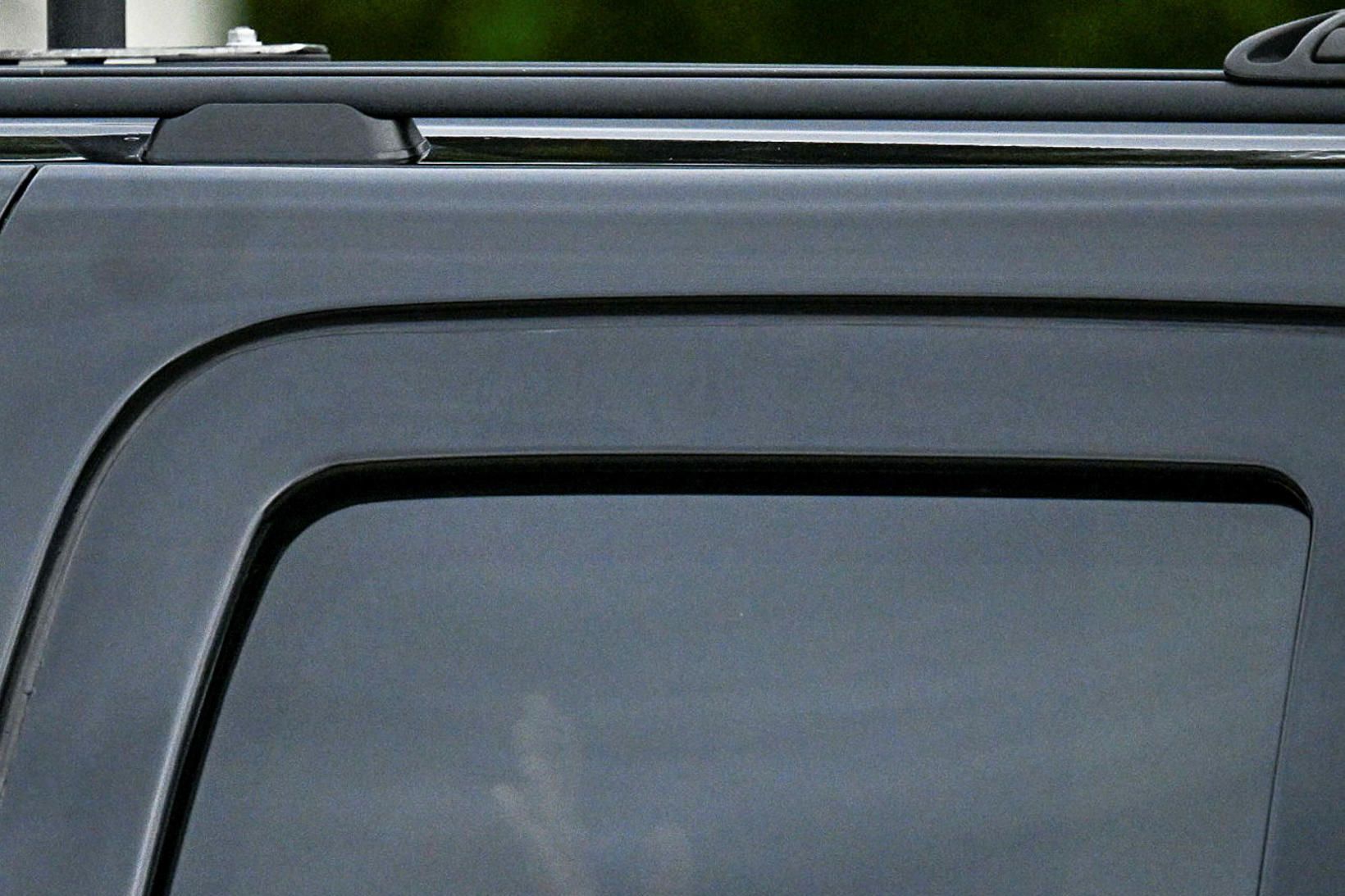 Donald Trump, verðandi Bandaríkjaforseti, vinkar innan úr Chevrolet Suburban bifreið …