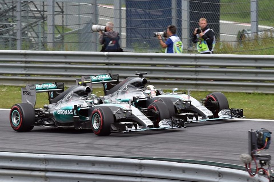 Mercedesbílarnir koma hlið við hlið að fyrstu beygju, Rosberg nær, Hamilton fjær.