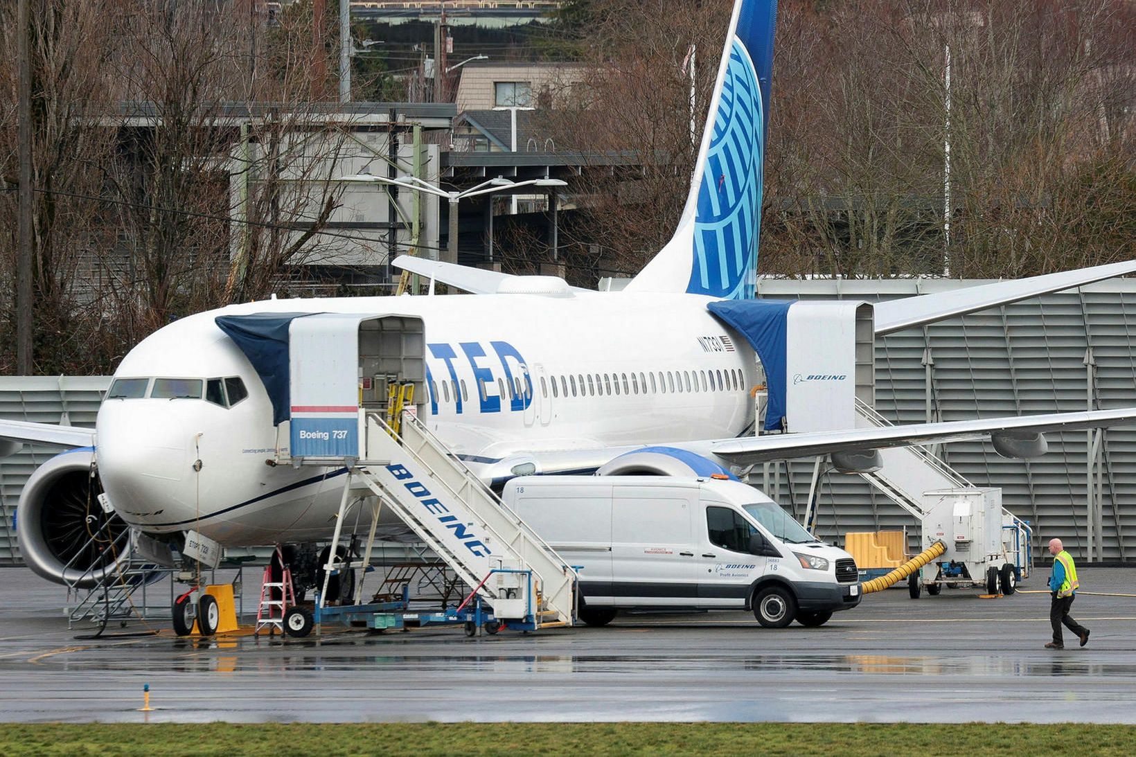 Maður gengur fram hjá flugvél United Airlines, Boeing 737 MAX …