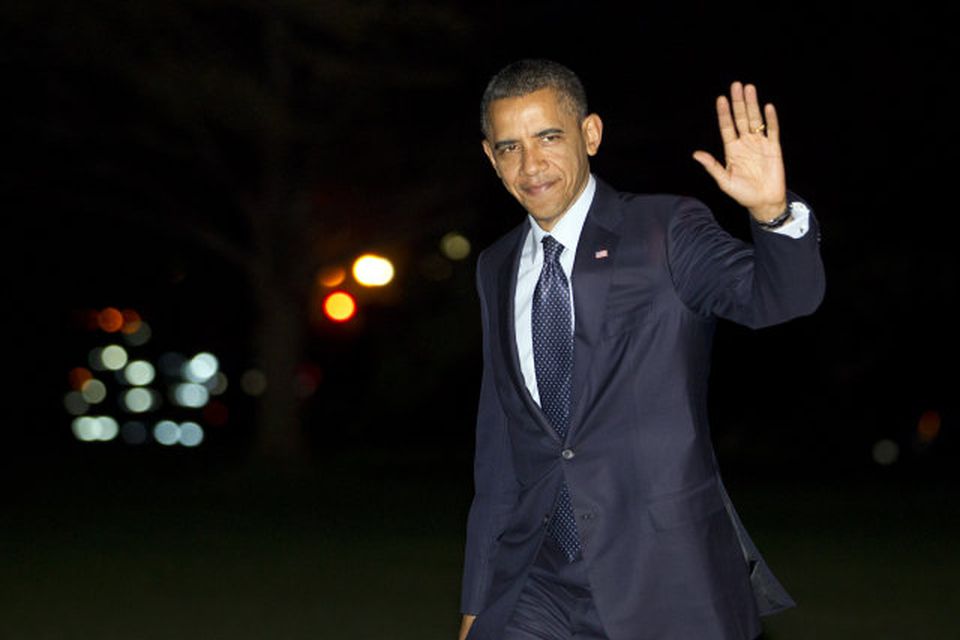 Barack Obama veifar til blaðamanna.