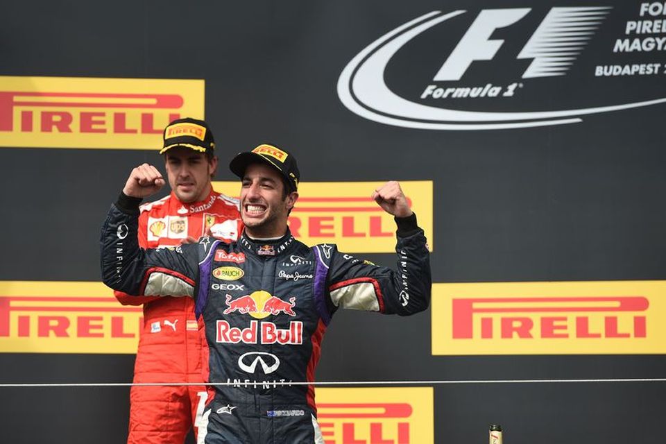 Daniel Ricciardo gengur út á verðlaunapallinn í Búdapest. Fernando Alonso hefur tekið sér stöðu á …