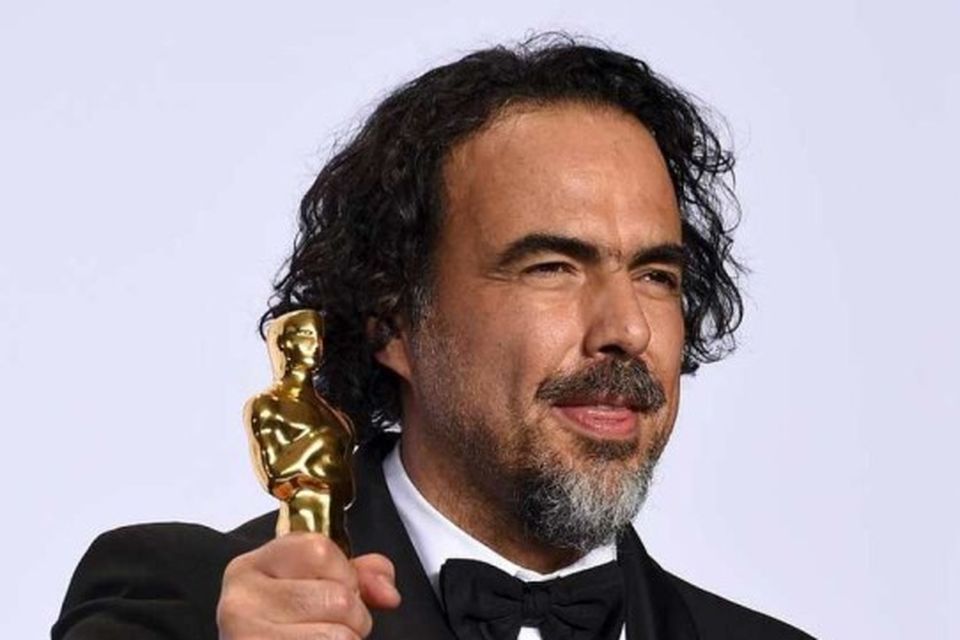 Alejandro G. Iñárritu kreppir hnefann um styttuna.