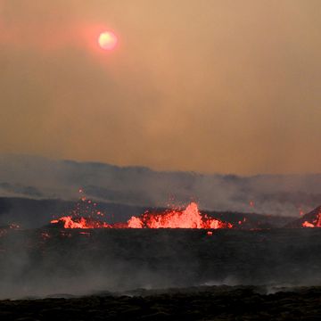 Lava spewing from volcanic fissures while toxic gases rise from the ground.