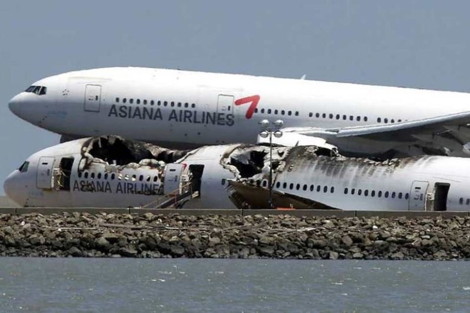 Vél frá flugfélaginu Asiana við hlið flaks vélar frá sama flugfélagi á vellinum í San …