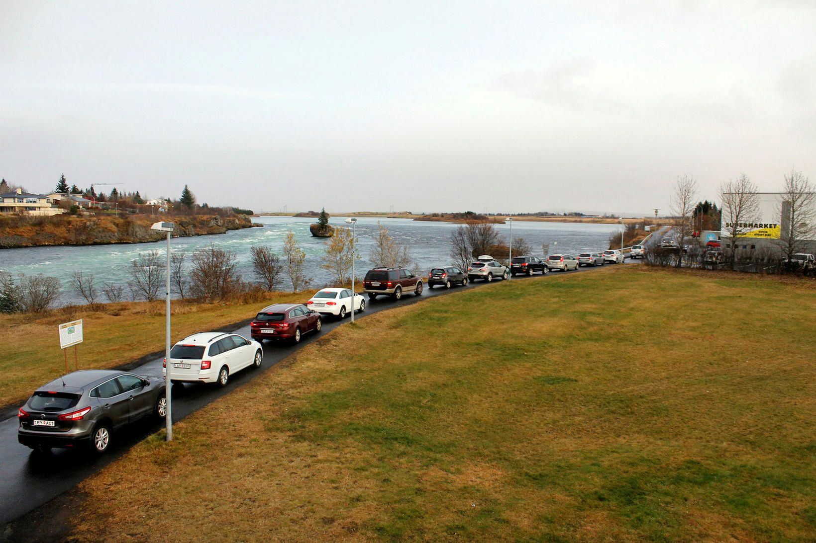 Biðröð bíla á bökkum Ölfusár, þar sem var fólk á …